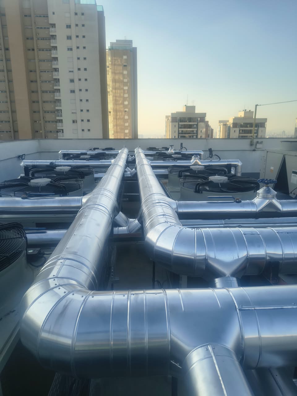 Tubulações industriais com acabamento em alumínio instaladas em uma cobertura